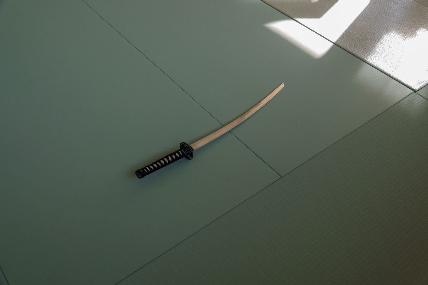 Sabre posé sur le tatami, dans le calme du dojo