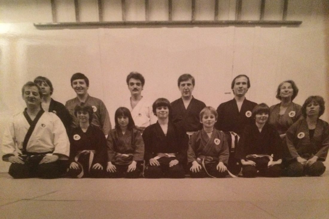 Photo de groupe du club en 1978, celle de l'affiche du 50ᵉ : pratiquants en kimono assis en rang au bord du tatami